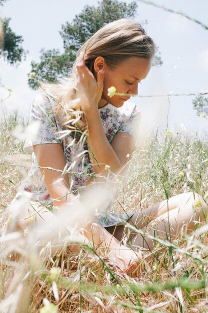 Foto jonge vrouw zit op het veld.