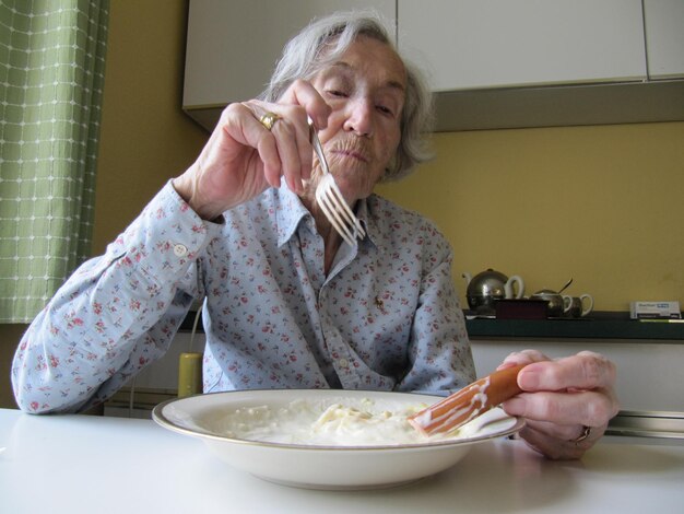 Foto jonge vrouw zit thuis op tafel.