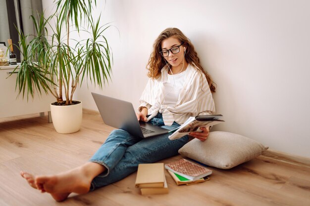 Jonge vrouw zit thuis te leren zich voor te bereiden op een examen met behulp van literatuur laptop concept van kennis