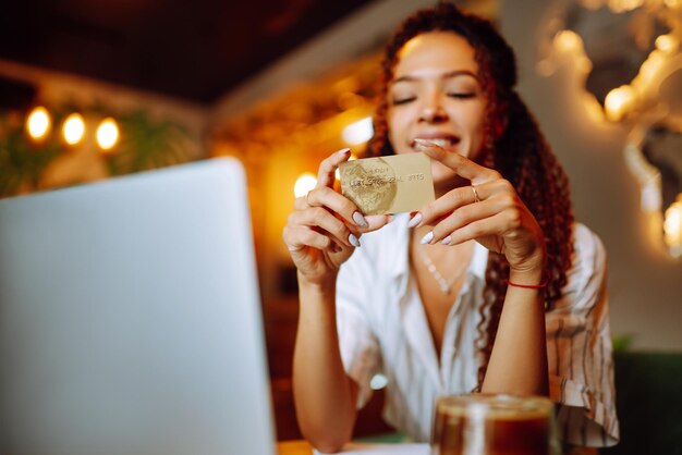 Jonge vrouw zitten in cafe maken van online winkelen met creditcard en laptop Online winkelen