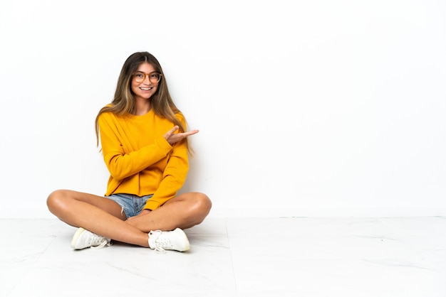 Jonge vrouw zittend op de vloer geïsoleerd