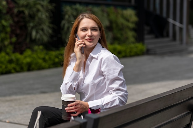 jonge vrouw zittend op een bankje uitrusten na het winkelen in het winkelgebied