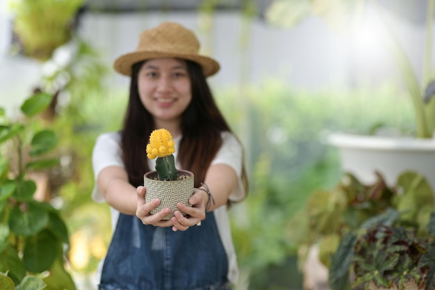 Jonge vrouw zorgt voor bomen planten en verzorgen van apparatuur planten in kassen kleine bedrijven