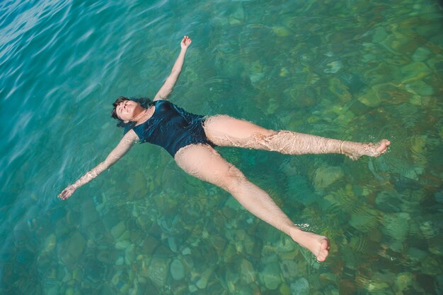Jonge vrouw zwemmen in blauwe azuurblauwe water zomervakantie