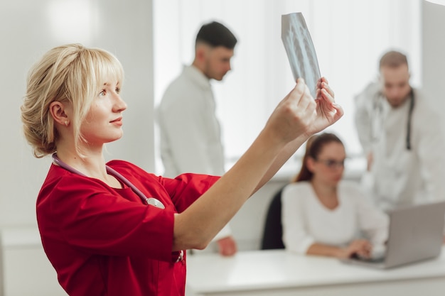 Foto jonge vrouwelijke arts in het ziekenhuis die x-ray bekijken