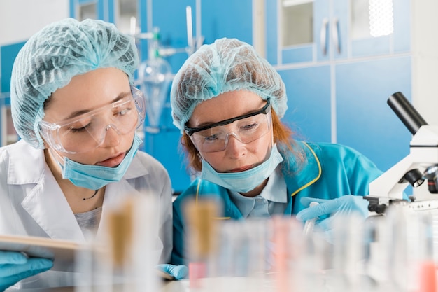 Foto jonge vrouwelijke artsen die werken aan een vaccin