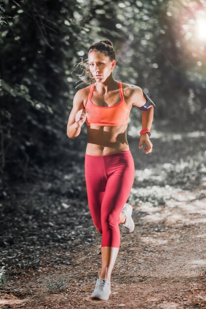 Jonge vrouwelijke atleet die in het park joggt