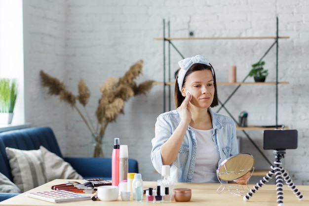 Jonge vrouwelijke blogger die een instructievideo opneemt voor haar beautyblog over cosmetica