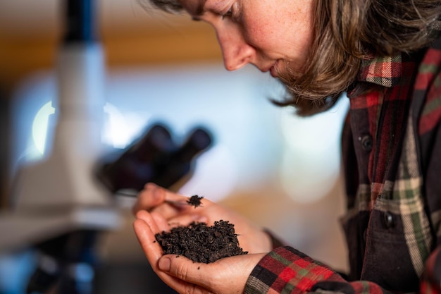 jonge vrouwelijke bodemwetenschapper die een bodem in haar hand houdt in een bodemlaboratorium in Australië in een laboratorium
