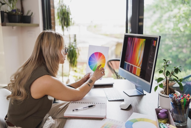 Jonge vrouwelijke freelancer die er attent uitziet terwijl ze werkt vanuit haar thuiskantoor.