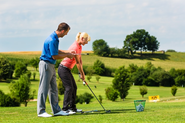 Jonge vrouwelijke golfspeler op cursus