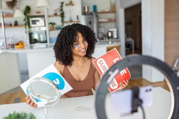 Jonge vrouwelijke influencer met ooglapjes die haar smartphone gebruikt voor het filmen van een vlogpost