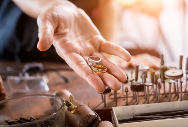 Jonge vrouwelijke juwelier die sieraden maakt in een werkplaats