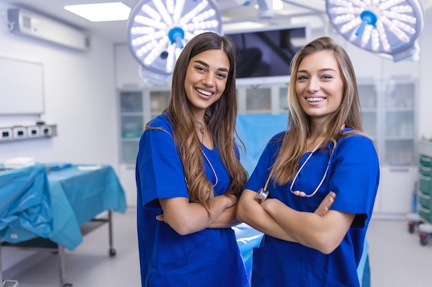 Jonge vrouwelijke medische professionals staan samen concept van gezondheidsbescherming Succesvol team van artsen kijken naar de camera en glimlachen terwijl ze in het ziekenhuis staan