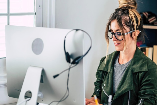 Foto jonge vrouwelijke ondernemer aan het werk op de computer in de thuis kantoor werkplaats moderne vrouwelijke mensen met online slimme werk baan bedrijf leuk portret van meisje glimlachen en schrijven op het toetsenbord alleen