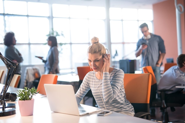 Jonge vrouwelijke ondernemer freelancer werken met behulp van een laptop in coworking space