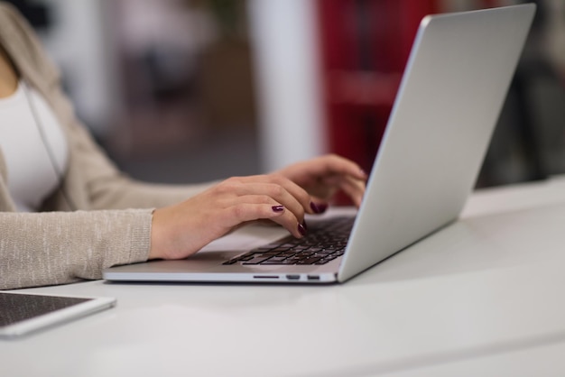 Jonge vrouwelijke ondernemer freelancer werken met behulp van een laptop in coworking space