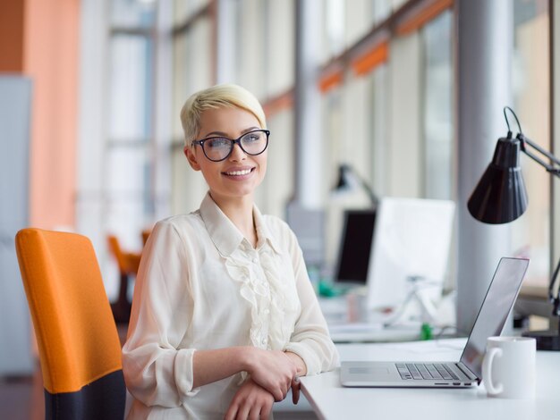 Jonge vrouwelijke ondernemer freelancer werken met behulp van een laptop in coworking space