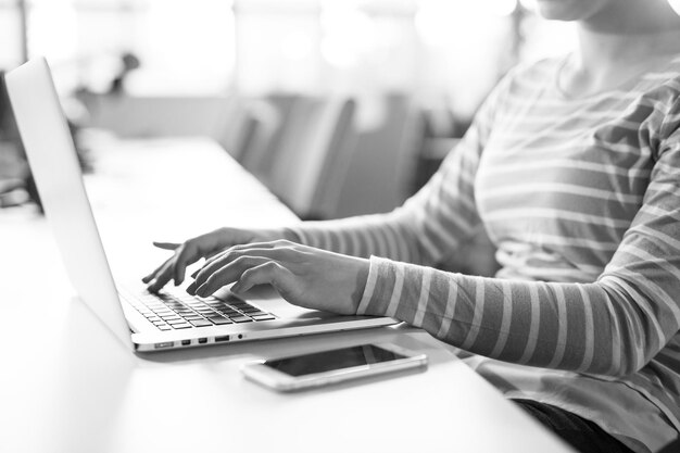 Jonge vrouwelijke ondernemer freelancer werken met behulp van een laptop in coworking space