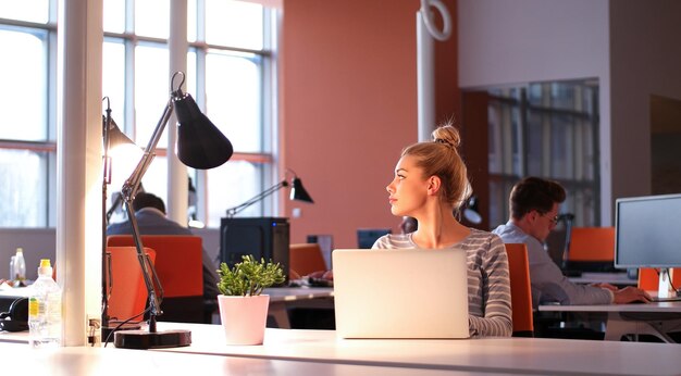 Jonge vrouwelijke ondernemer freelancer werken met behulp van een laptop in coworking space