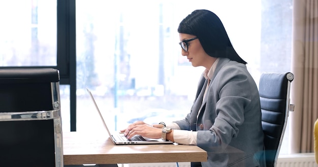 Jonge vrouwelijke ondernemer freelancer werken met behulp van een laptop in coworking space