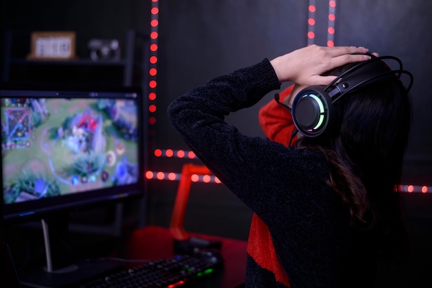 Jonge vrouwelijke professionele streamer en gamer met headset die online videogames speelt