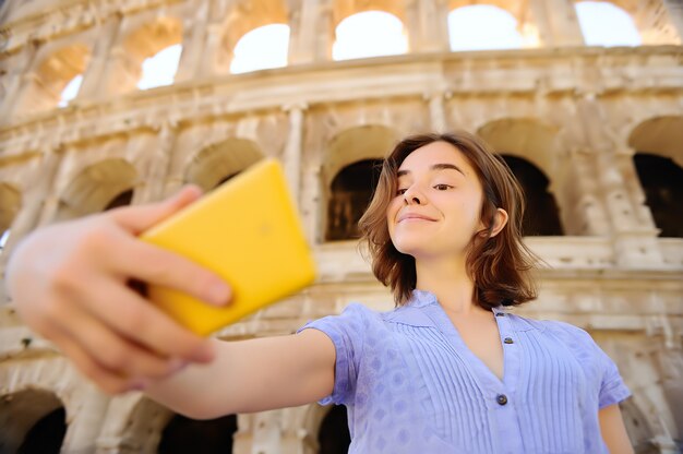 Jonge vrouwelijke reiziger die selfie foto maken die zich Colosseum in Rome, Italië bevinden