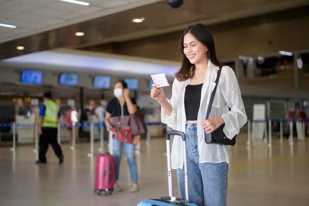 Jonge vrouwelijke reiziger met koffers op de internationale luchthaven