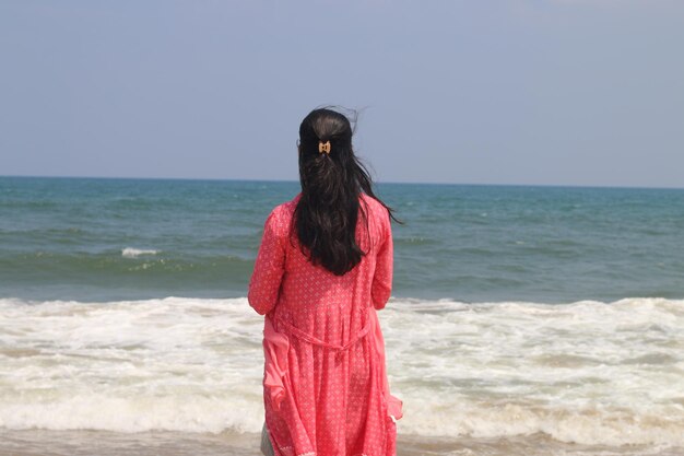 Jonge vrouwelijke reiziger op geweldig Chennai Marina Sea Beach met turquoise water
