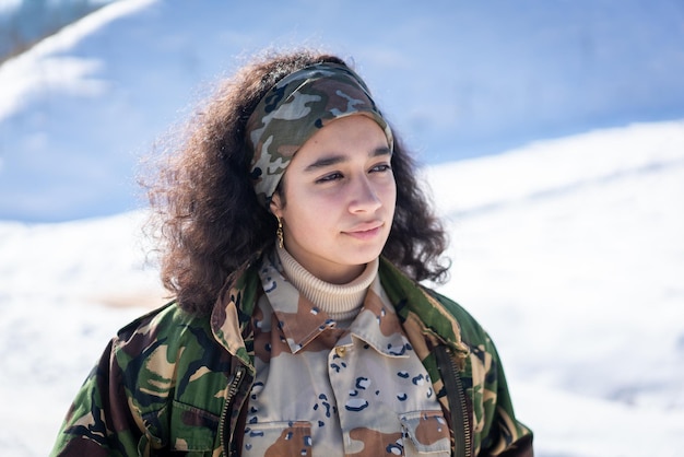 Jonge vrouwelijke soldaat in militair uniform op wintersneeuw. Foto van hoge kwaliteit