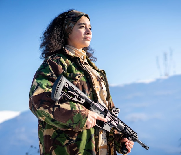 Jonge vrouwelijke soldaat in militair uniform op wintersneeuw. foto van hoge kwaliteit