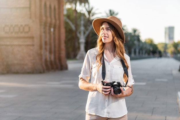 Jonge vrouwelijke soloreiziger die van een vakantie in Barcelona geniet en foto's van de stad maakt.