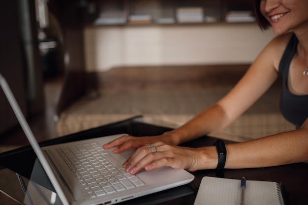 Jonge vrouwelijke student die laptop gebruikt, communiceert op internet met leraren