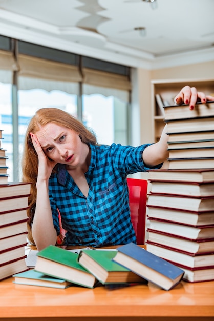 Foto jonge vrouwelijke student die voor examens voorbereidingen treft