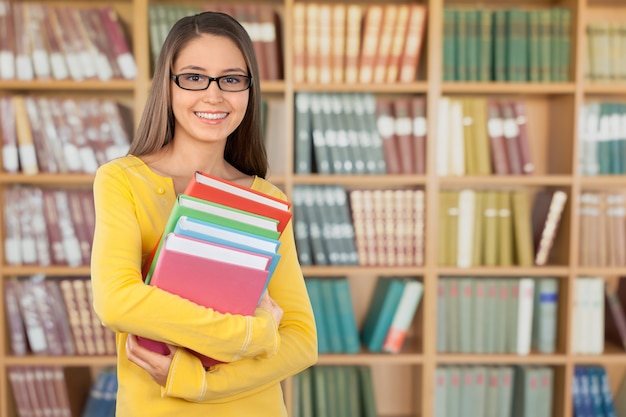 Jonge vrouwelijke student in bibliotheek