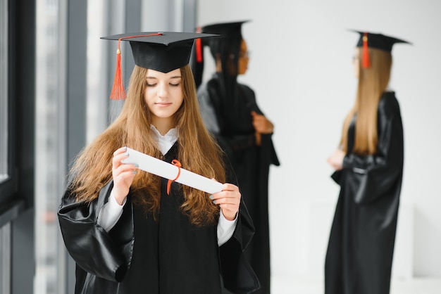 Jonge vrouwelijke student in gewaad viert haar afstuderen