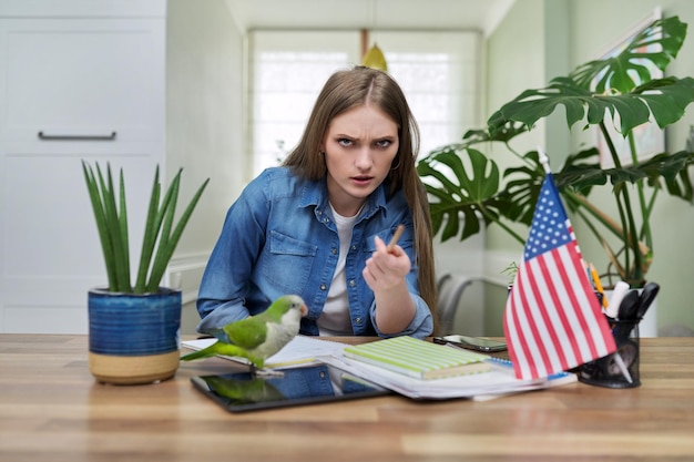 Jonge vrouwelijke student kijkend naar de camera USA vlag op tafel