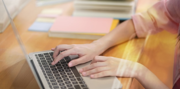 Jonge vrouwelijke student typen op laptop toetsenbord