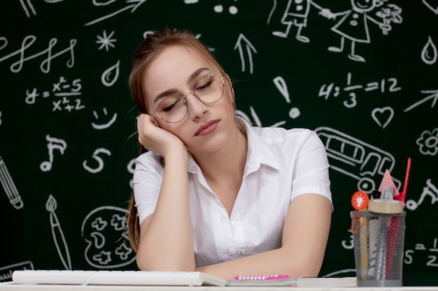 Jonge vrouwelijke studentenslaap in een klaslokaal