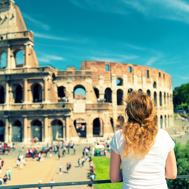 Foto jonge vrouwelijke toerist kijkt naar het colosseum in rome