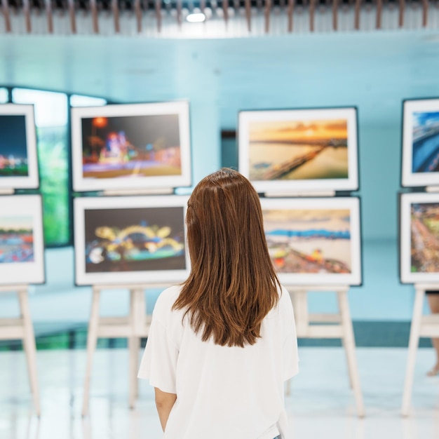 Foto jonge vrouwelijke toerist op zoek naar galerijtentoonstelling kunstfotografie en museumconcept