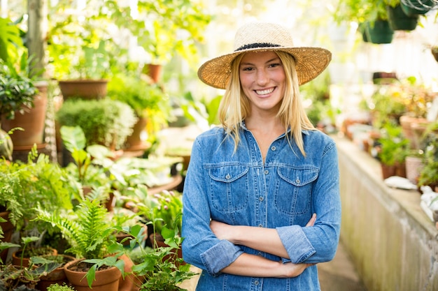 Jonge vrouwelijke tuinman bij serre