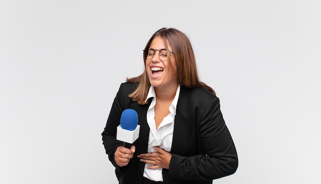 Jonge vrouwelijke verslaggever die hardop lacht om een hilarische grap, zich gelukkig en opgewekt voelt, plezier heeft