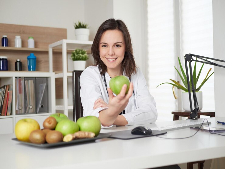 Jonge vrouwelijke voedingsdeskundige met een groene appel