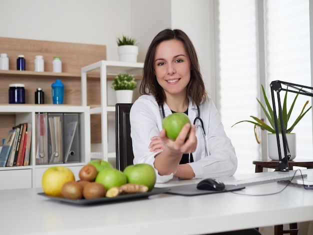 Jonge vrouwelijke voedingsdeskundige met een groene appel