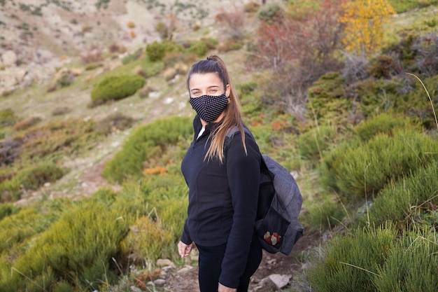 Jonge vrouwelijke wandelaar die op de berg loopt tijdens