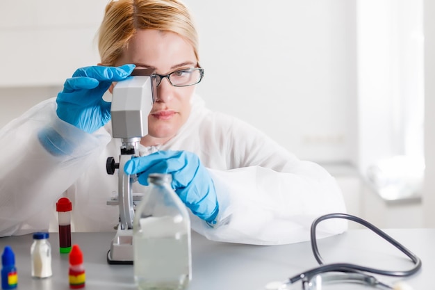 Jonge vrouwelijke wetenschapper die monster in laboratorium analyseert