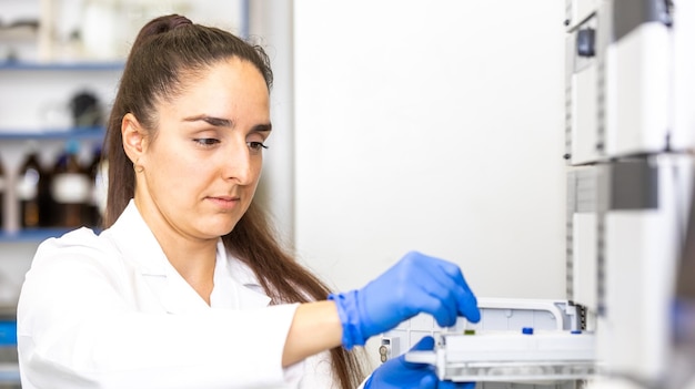 Foto jonge vrouwelijke wetenschapper in een onderzoekslaboratorium die een wetenschappelijk experimentlaboratoriumconcept creëert