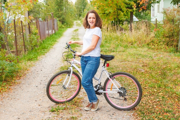 Jonge vrouwen berijdende fiets in het park van de de zomerstad in openlucht