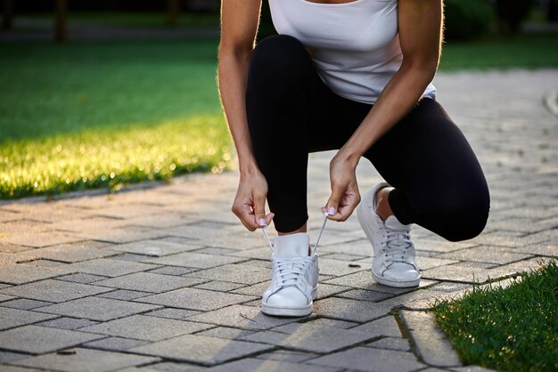 Jonge vrouwen bindende schoenveters alvorens te lopen